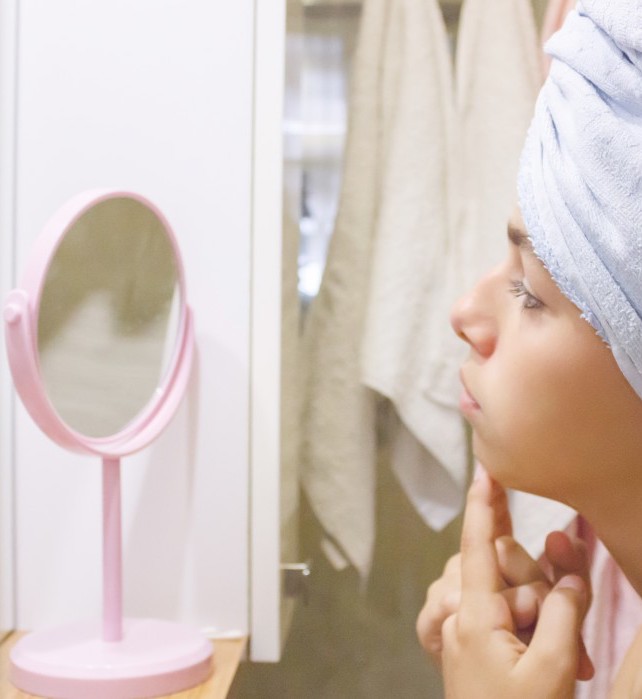 young-beautiful-teen-girl-in-a-towel-squeezes-a-pimple-acne-in-front-of-a-mirror_t20_Lzl89V