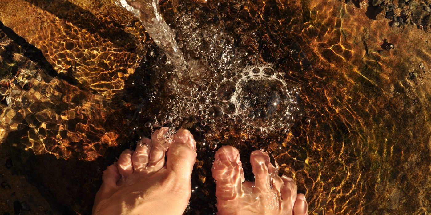 Person practicing traditional dew-treading after learning the history of hydrotherapy for natural health.