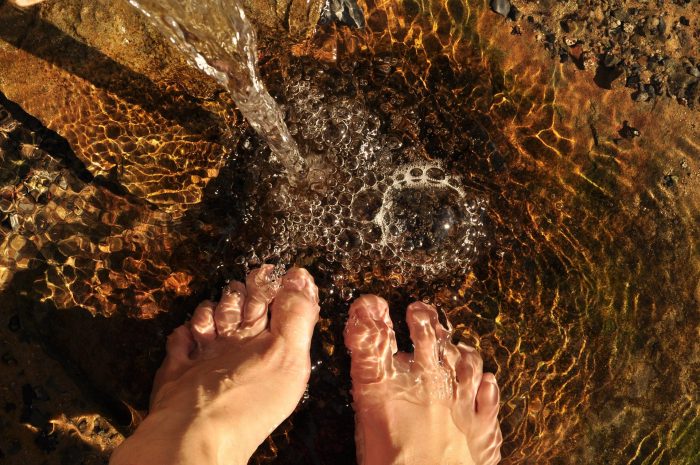 Person practicing traditional dew-treading after learning the history of hydrotherapy for natural health.